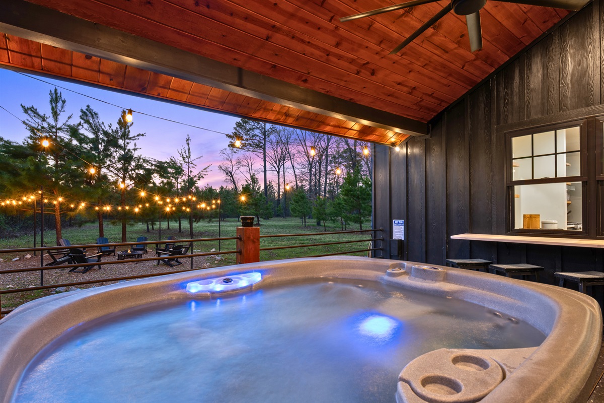 The hot tub glows softly at dusk, creating a peaceful and calming place to relax while taking in the surrounding scenery.
