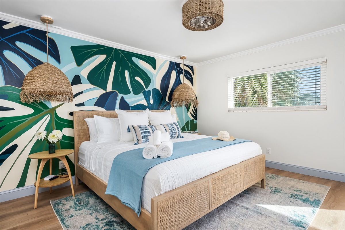 A spacious king suite with hand-painted mural accents and natural light.