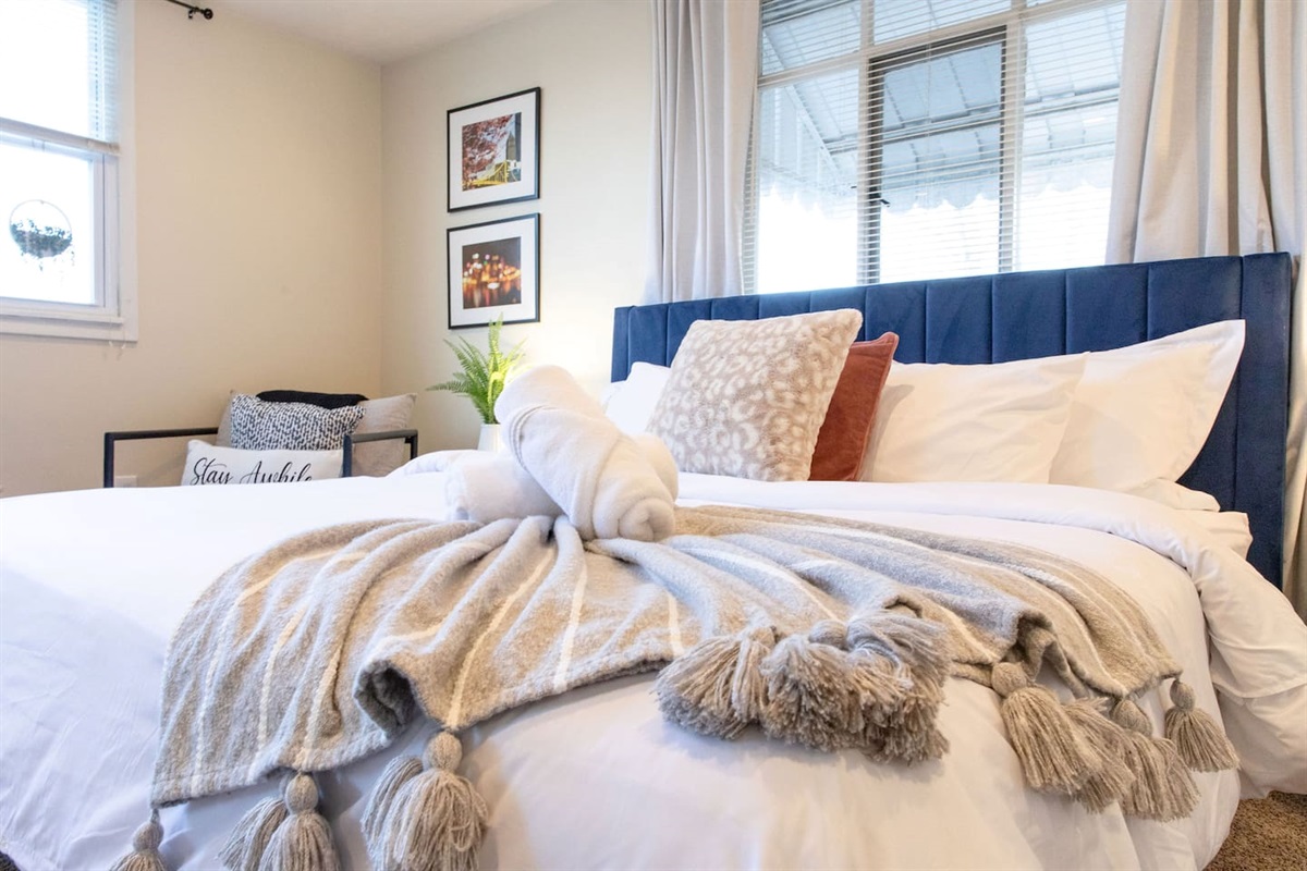 Cozy, spacious room with a queen-sized bed, TV, and a dedicated working space.