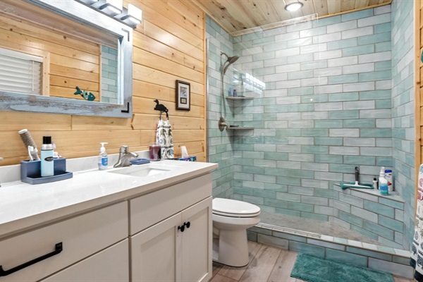 Unwind in the spa-like master bathroom after a day on the lake, with a tiled, floor-to-ceiling walk-in shower and stone countertops just steps away from the master bedroom