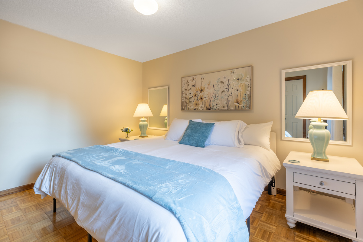 A massive king bed is located in a secondary bedroom on the second floor.