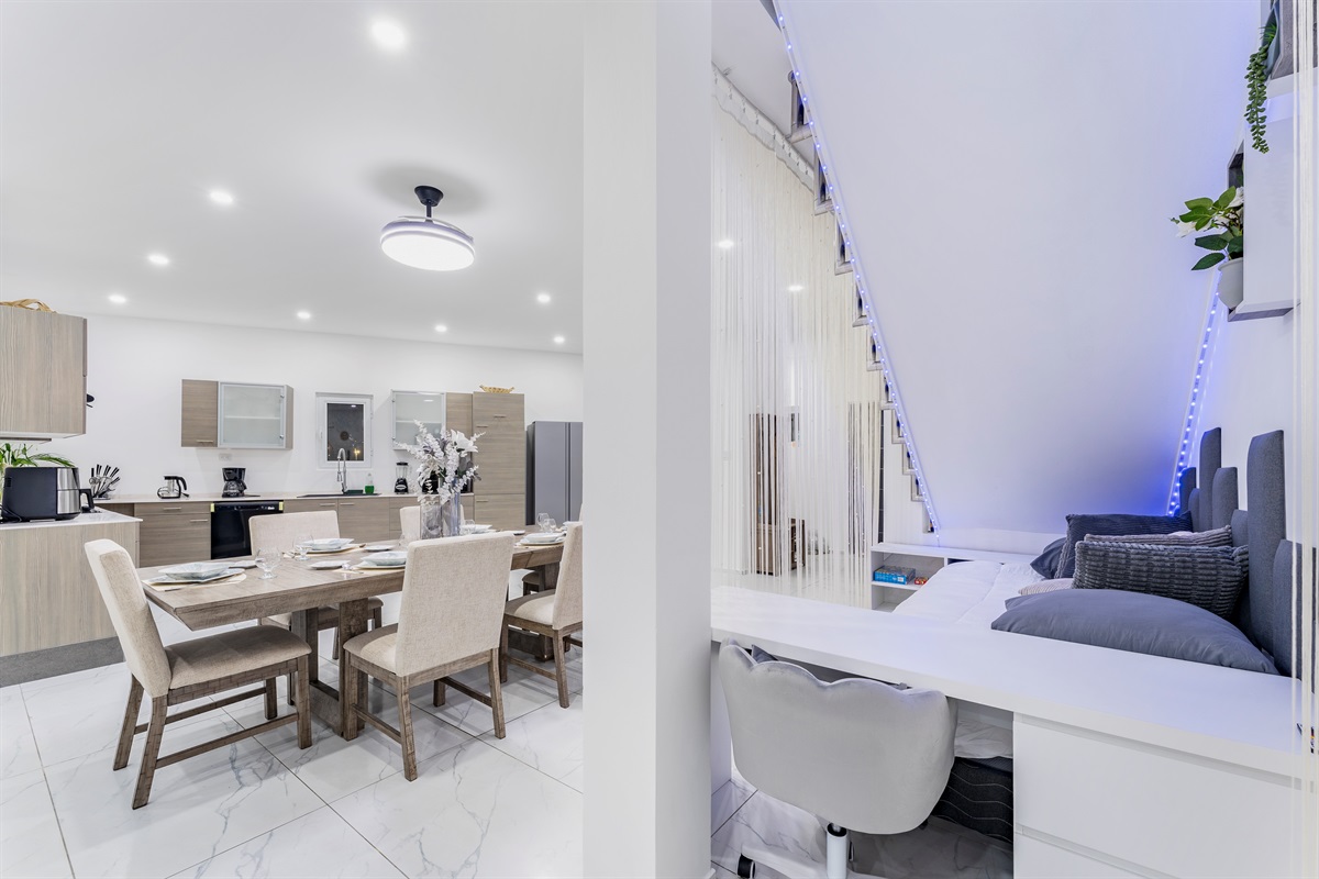 Under-stair lounge with LED lighting next to dining area