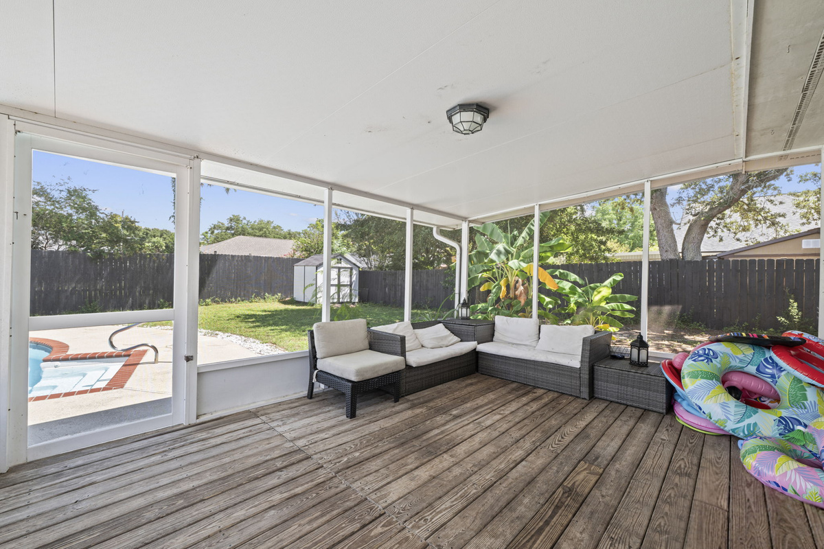 A screened-in patio with comfy wicker seating — the perfect shady spot to relax steps from the pool.