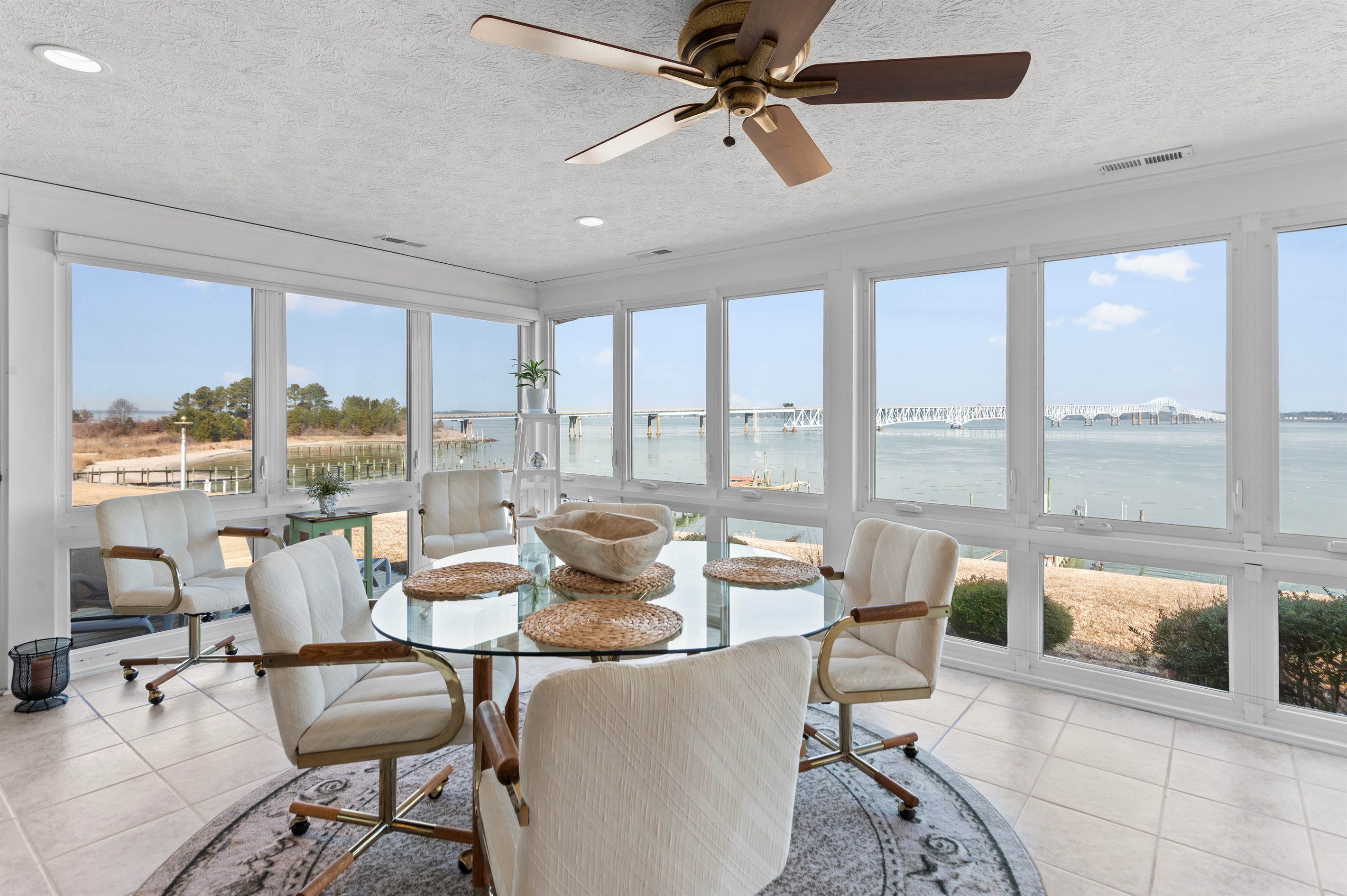 Sunroom Retreat: Bask in stunning waterfront views while enjoying meals and relaxation here!