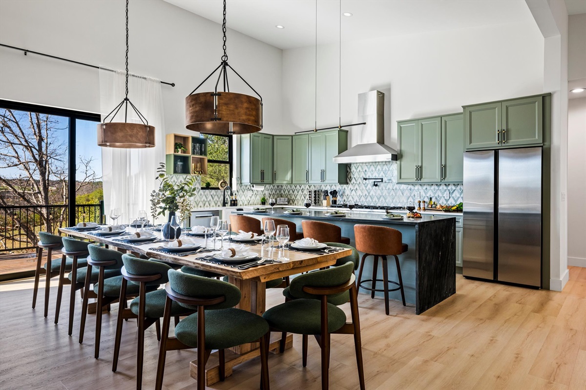 {Dining} Gather around a one-of-a-kind raw-edge dining table crafted from a tree on the property, with seating for 12+, plus an additional 4 at the oversized island — all anchored by a fully equipped chef’s kitchen designed for effortless group m