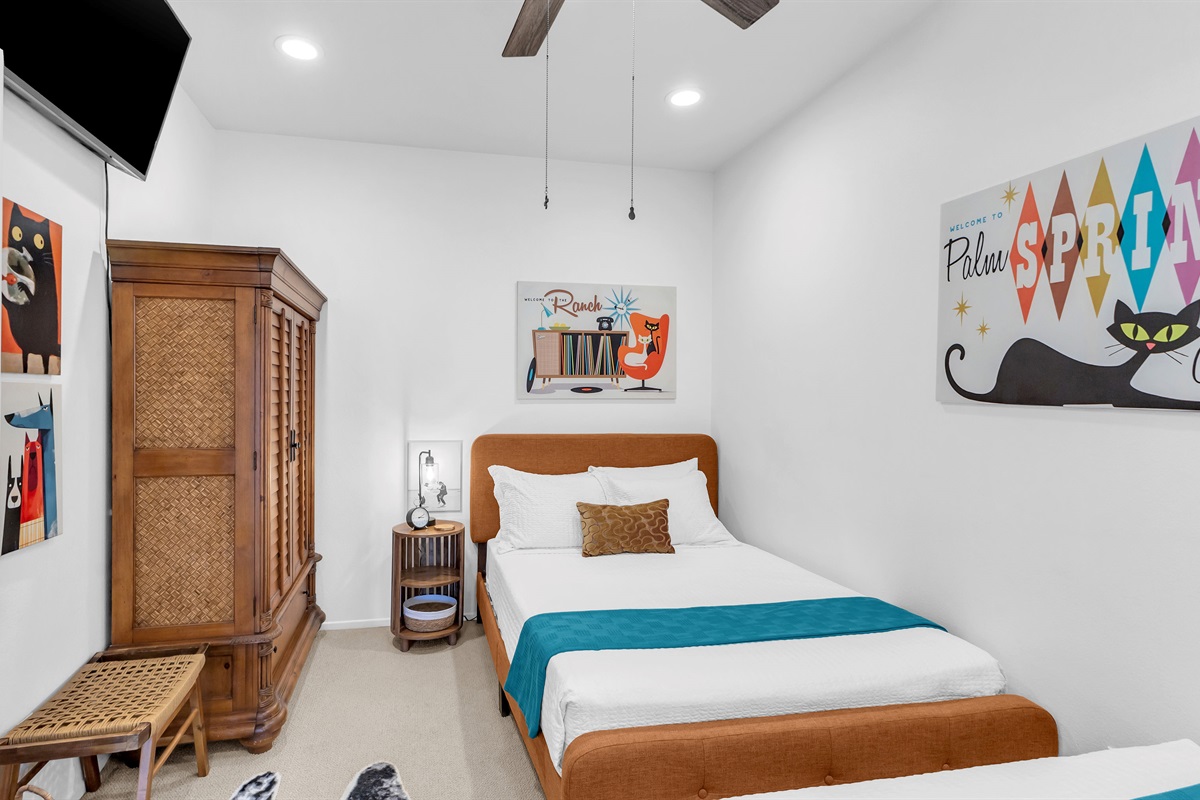 Retro-inspired guest room with twin beds, Palm Springs artwork, and vibrant mid-century flair