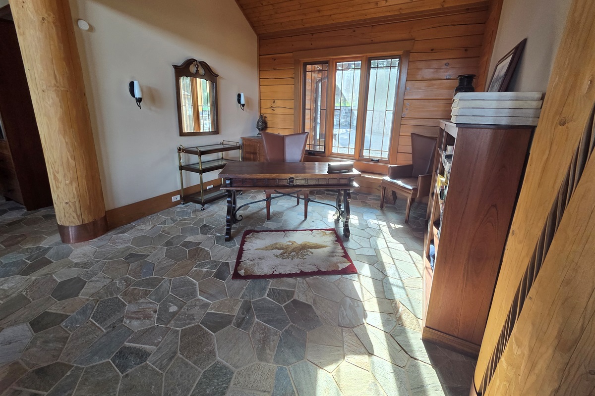 A versatile office space featuring a desk and shelves stocked with games, perfect for remote work or family fun.