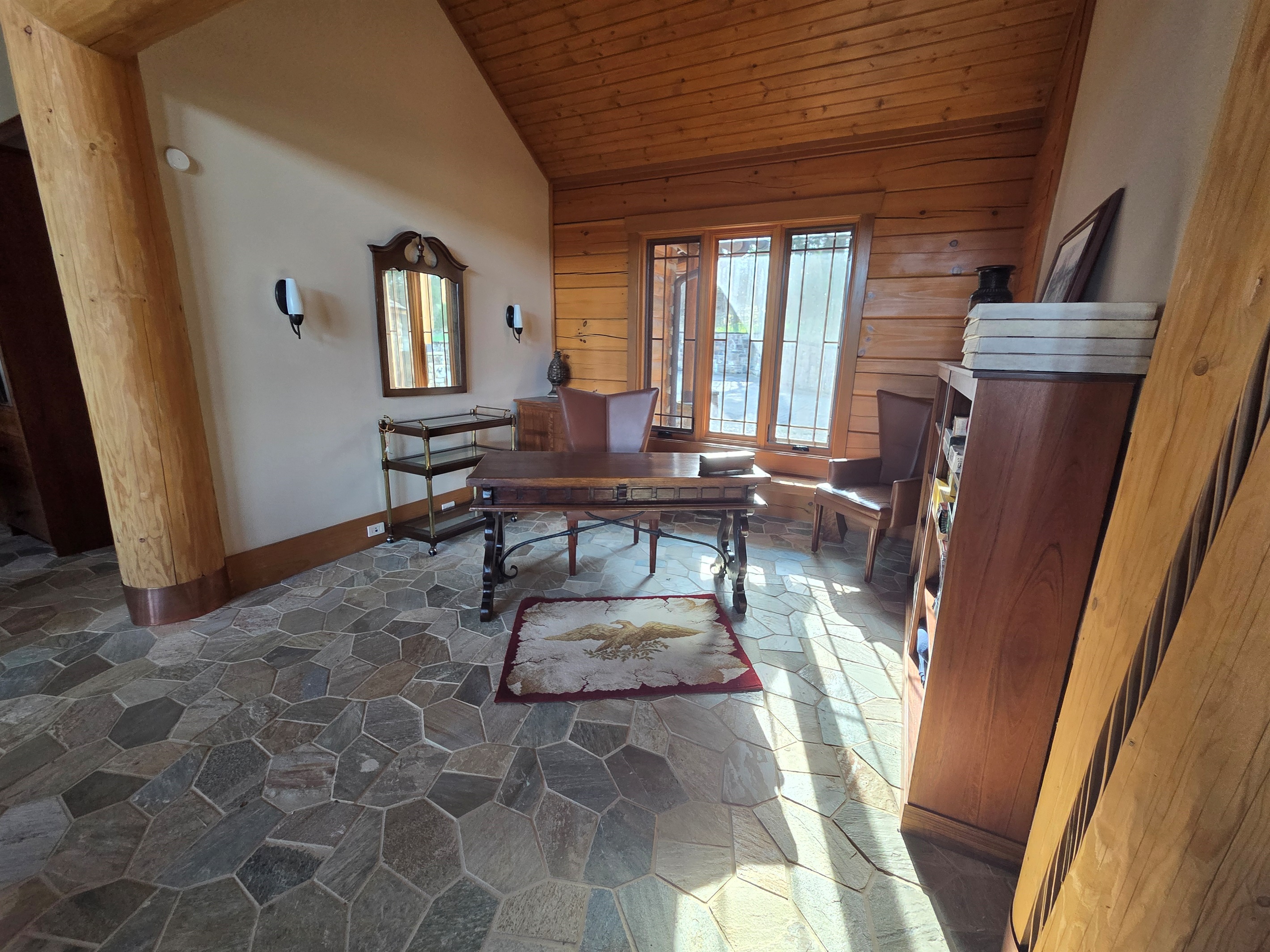 A versatile office space featuring a desk and shelves stocked with games, perfect for remote work or family fun.