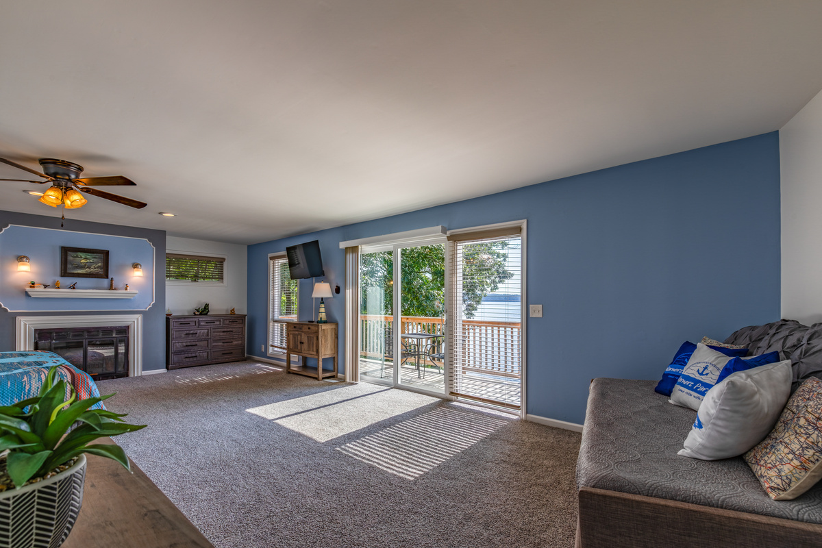 The spacious upstairs king suite includes a sitting area, fireplace, Roku TV, and access toward the lake-facing deck.