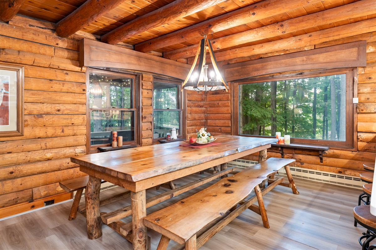 Share meals and memories at the handcrafted farmhouse table with forest views through large cabin windows.
