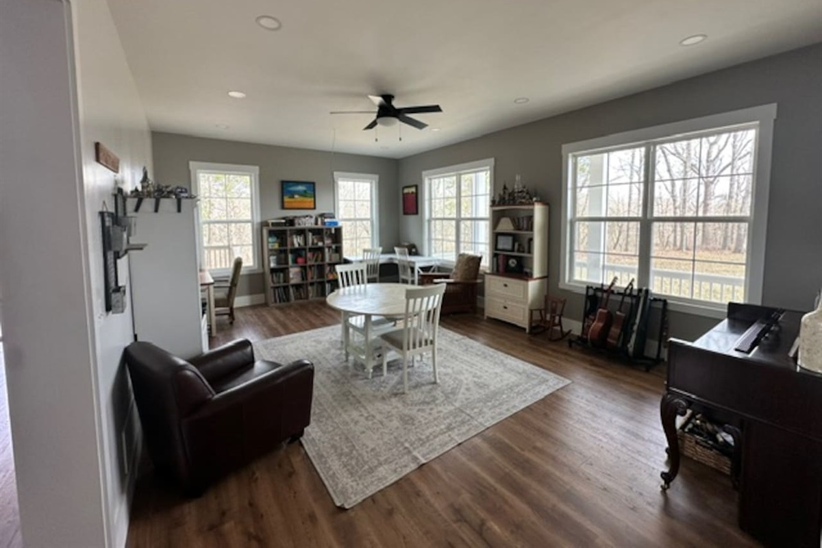 Our library features three work spaces, two comfy chairs for reading, PLENTY of books (we love the classics!), children's art supplies & crafts, as well as a piano and a few guitars. Beautiful views from these windows too. Open to living room/foyer.