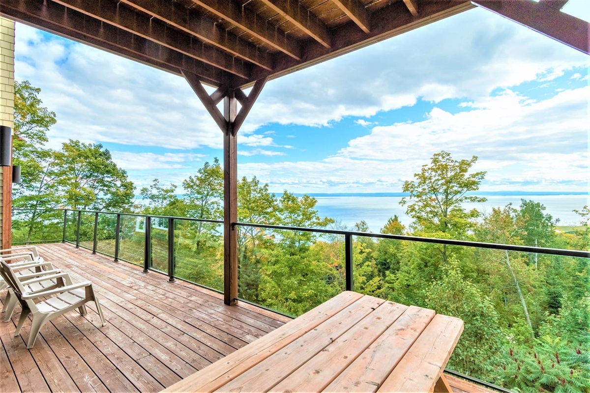Grande terrasse avec chaises et vue panoramique sur le fleuve.