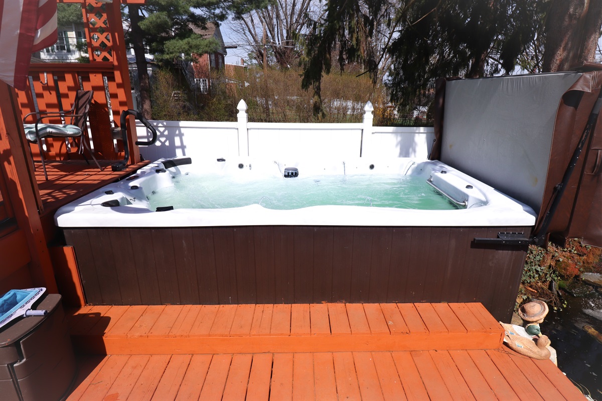 Private backyard oasis with swim spa, fire pit, and pond views