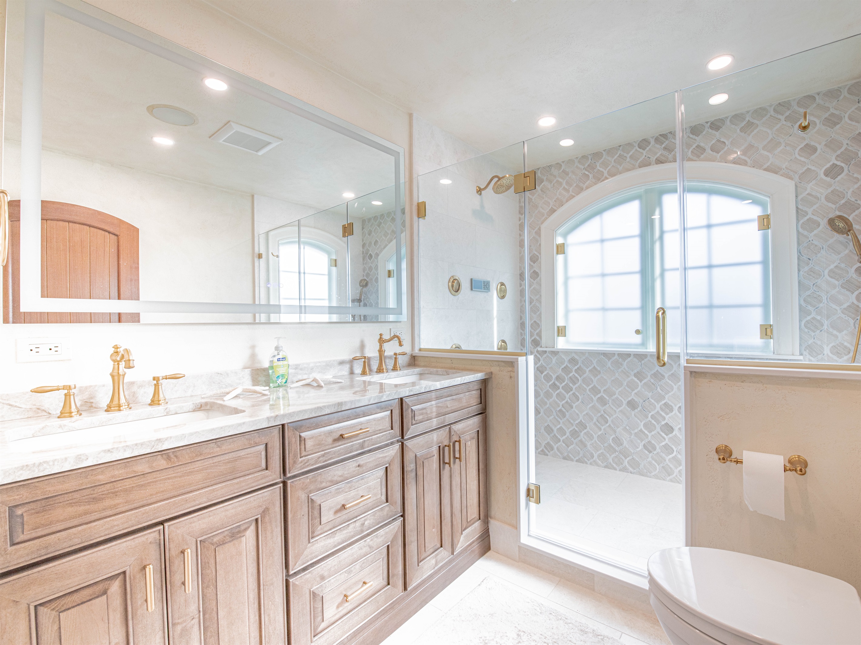 King ensuite bath with double vanity sinks and stunning tiled shower