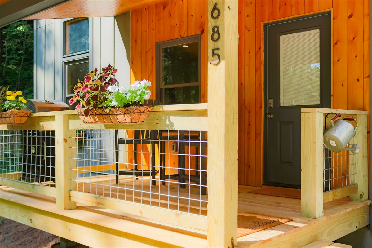 Small but spacious covered deck with seating for two and a grill