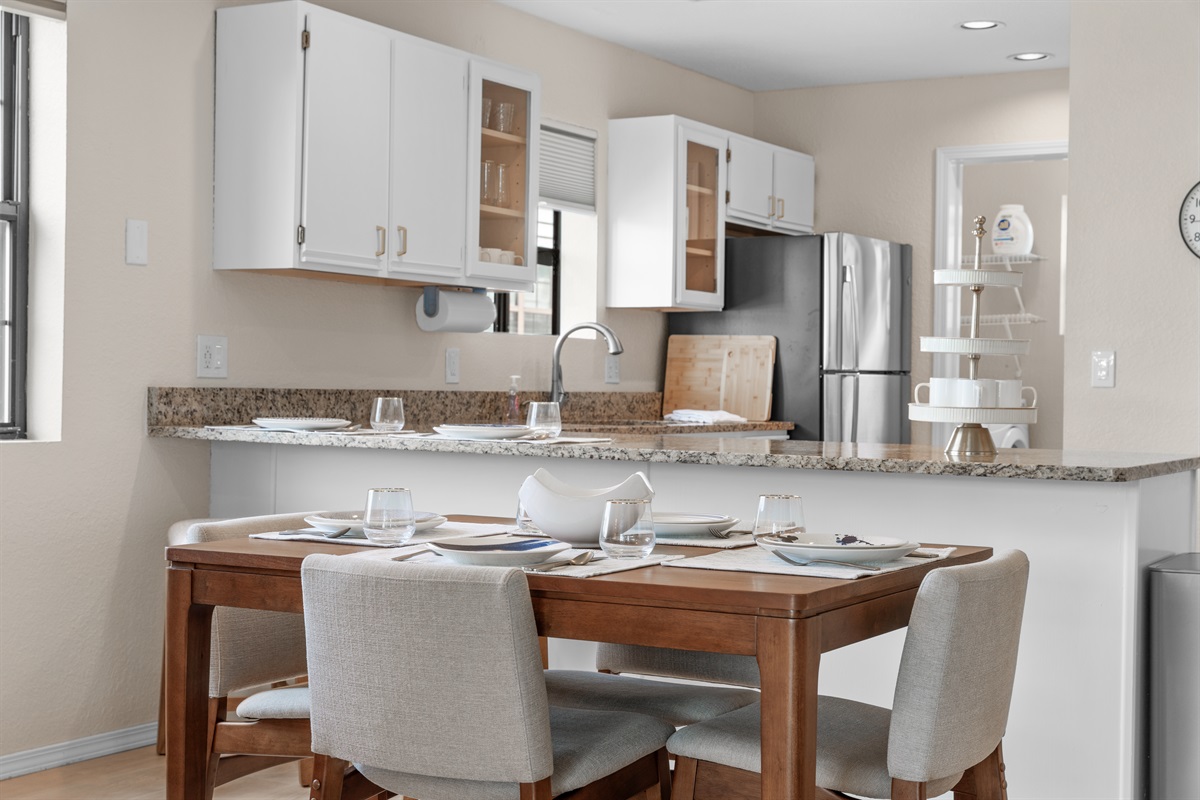 ☕ Everything you need for meals or morning coffee—stainless range, microwave, fridge with filtered water, and sleek midcentury lighting above.