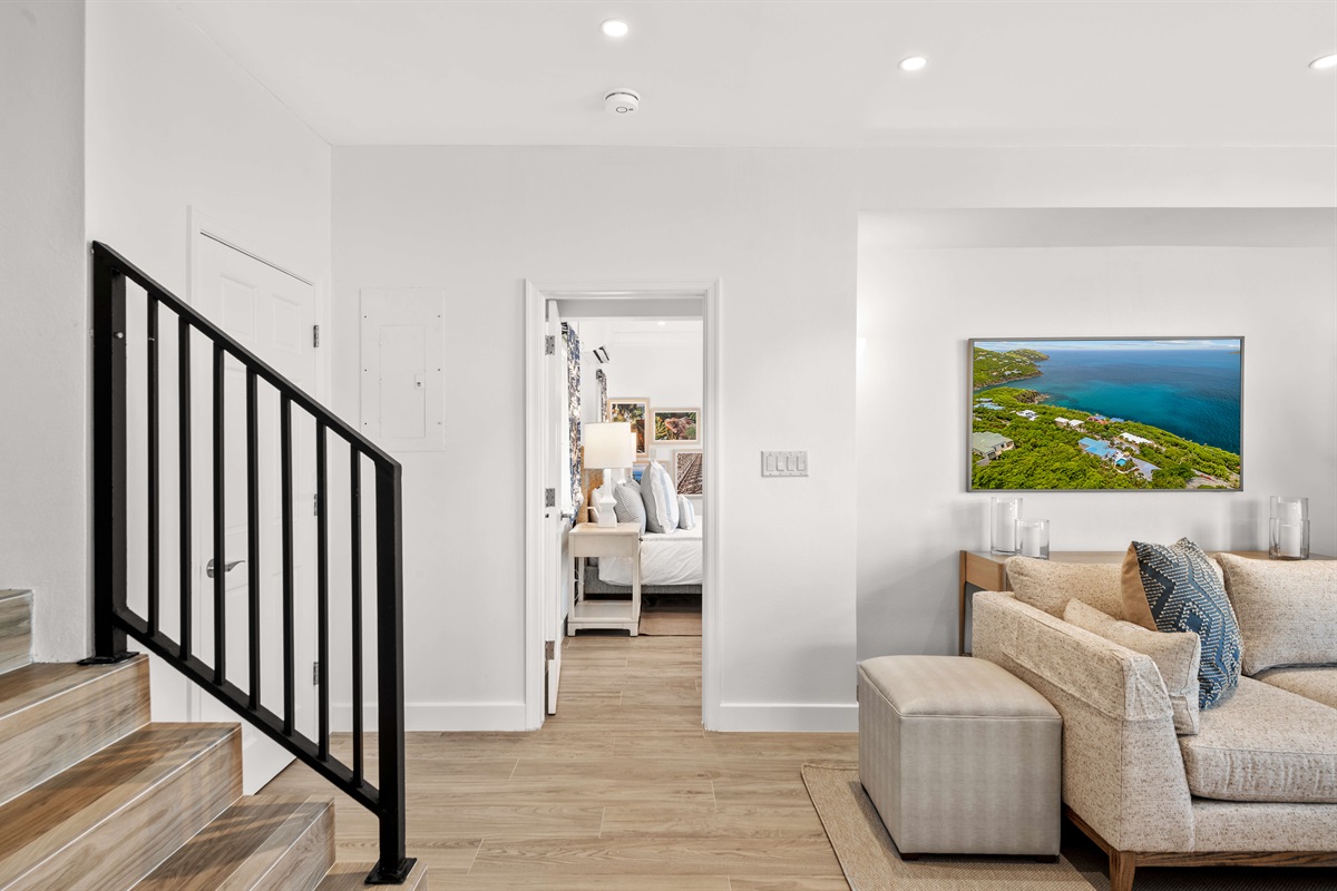 Open stairwell with natural light and modern railing design connecting both floors.