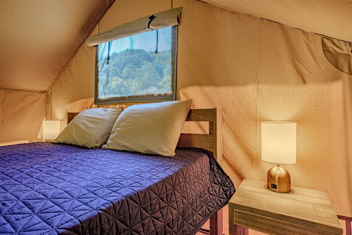 Your cozy centerpiece. Sink into this inviting bed after a day of exploring. Notice the stylish bedside lamps offering warm, ambient light.