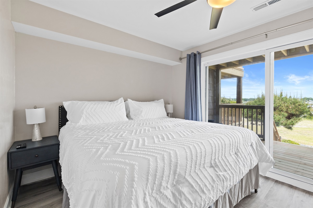 King bedroom with plush bedding and direct access to the private balcony