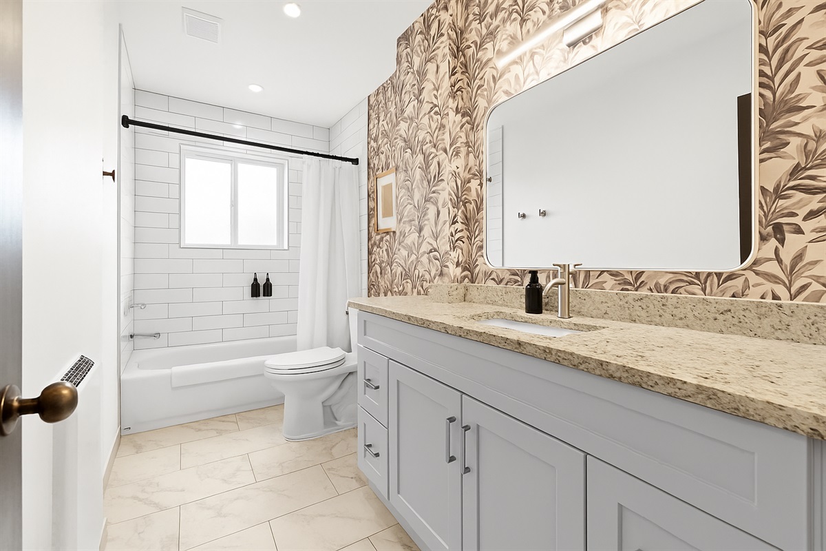 Refresh in a modern bathroom featuring white tile, granite countertops, and a full-size tub/shower combo.