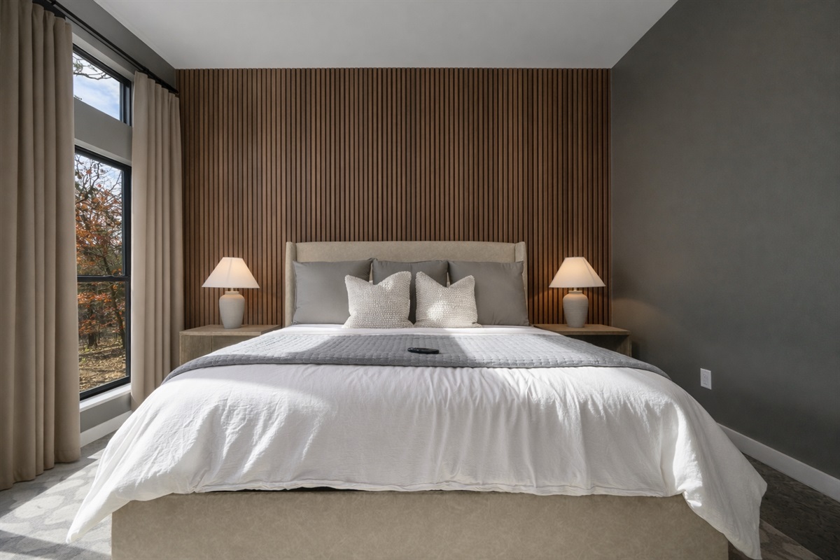 King Suite 1 - Large and spacious suite with teak wood paneling, smart TV, premium king mattress, and luxury bedding. Includes stunning views of the hardwood forest. 