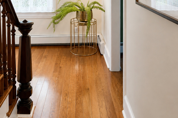 The second floor landing — original hardwood floors, walnut staircase, and a framed photo of the cottage as it looked in 1974. Some things haven’t changed a bit.