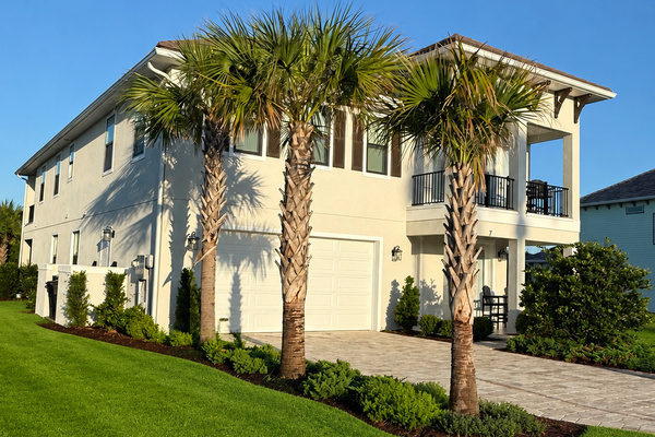 Three tall palms stand guard over your home away from home. Pull into the drive, unload the beach gear, fling open the doors—this is the happy chaos of arrival, the first deep breath of a week that already feels like it will be unforgettable.