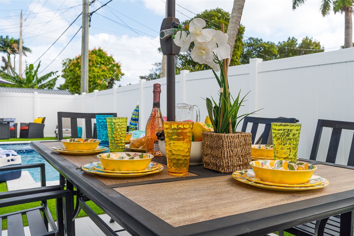Enjoy al fresco dining by your private heated pool in this sunny Florida backyard, complete with vibrant outdoor seating and lush tropical vibes.