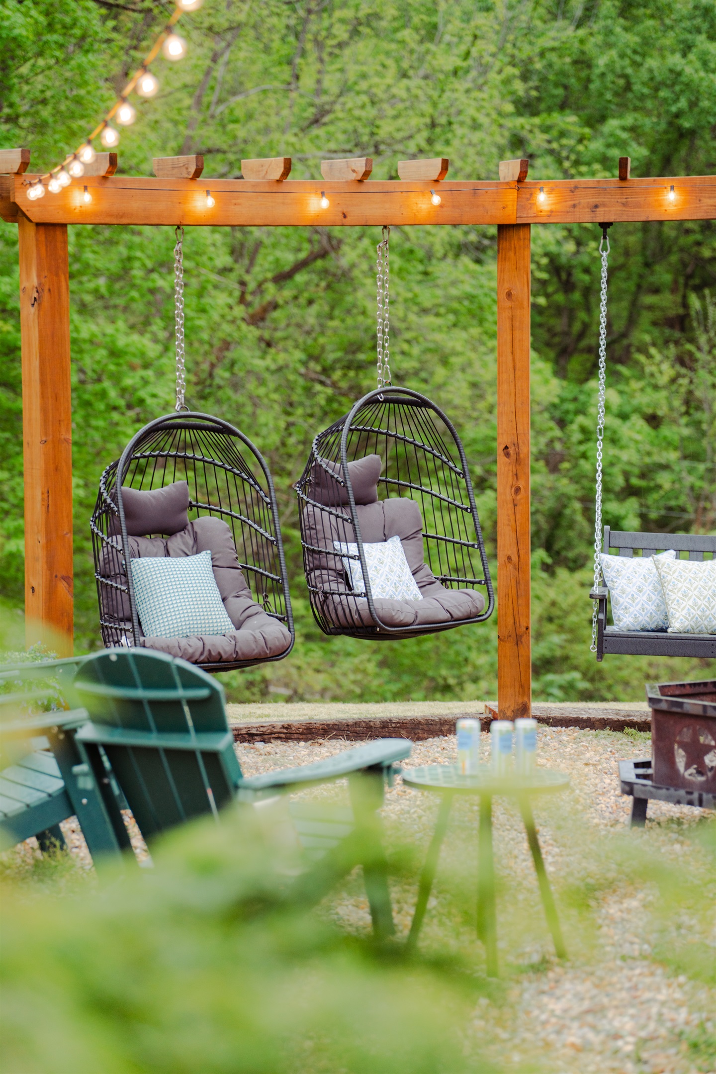 Unwind by the firepit in hanging egg chairs beneath a canopy of twinkling lights