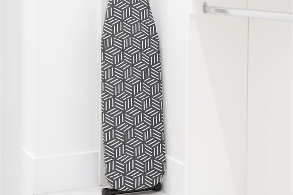 Closet space featuring an ironing board and neatly folded fresh linens.