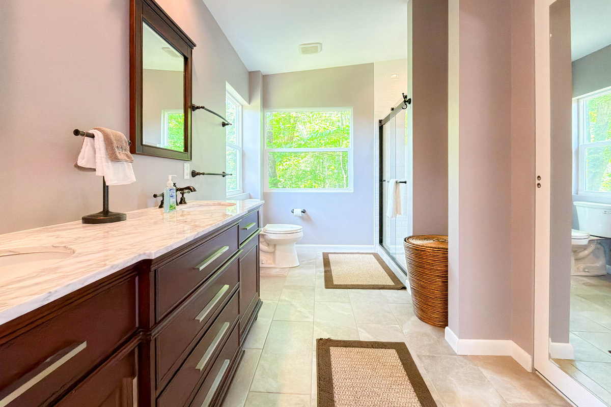 full bathroom in the en-suite master bedroom. Dual vanity sinks, low clearance walk-in shower with glass doors.