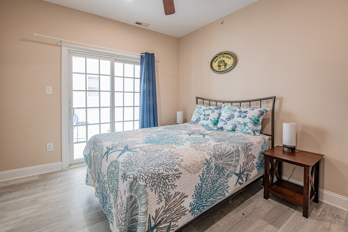 Bedroom 1 with Coastal Bedding and Sliding Glass Door Access