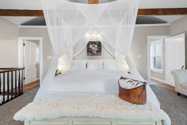 Private primary suite with a king canopy bed and a window cupola that glows at night.