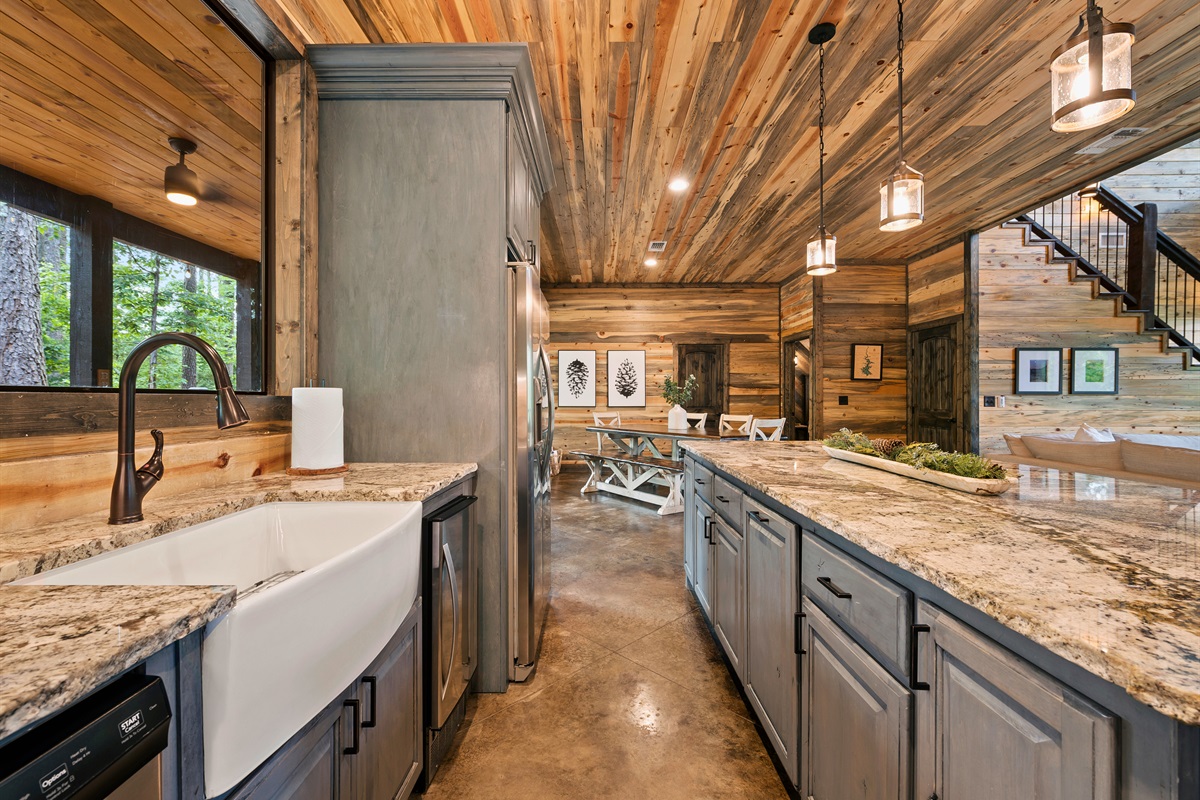 Experience culinary delights with a fully equipped kitchen featuring a charming farmhouse sink, elegant granite countertops, and modern cabinetry.