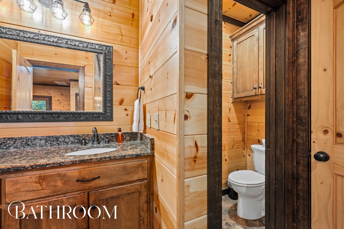 Bathroom with granite vanity and natural wood accents.