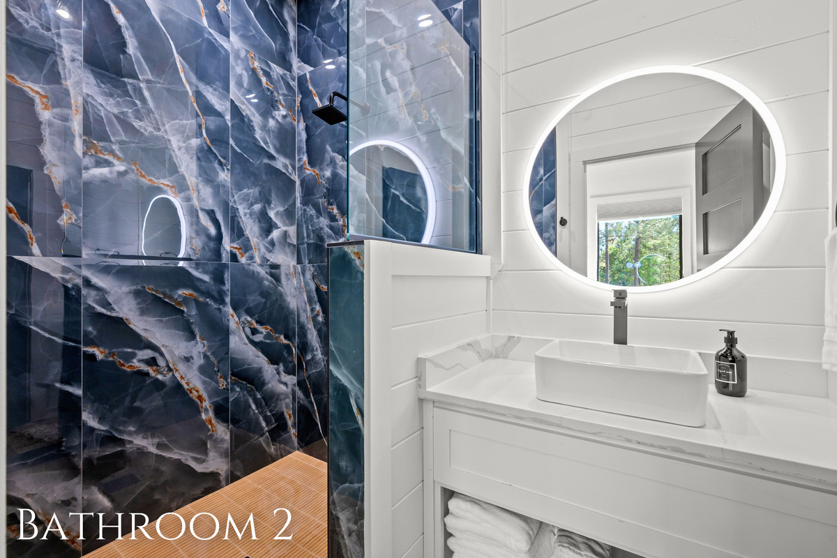 Bold tile details, modern fixtures, and warm lighting come together to create a bathroom space that feels polished while still remaining practical for guests.