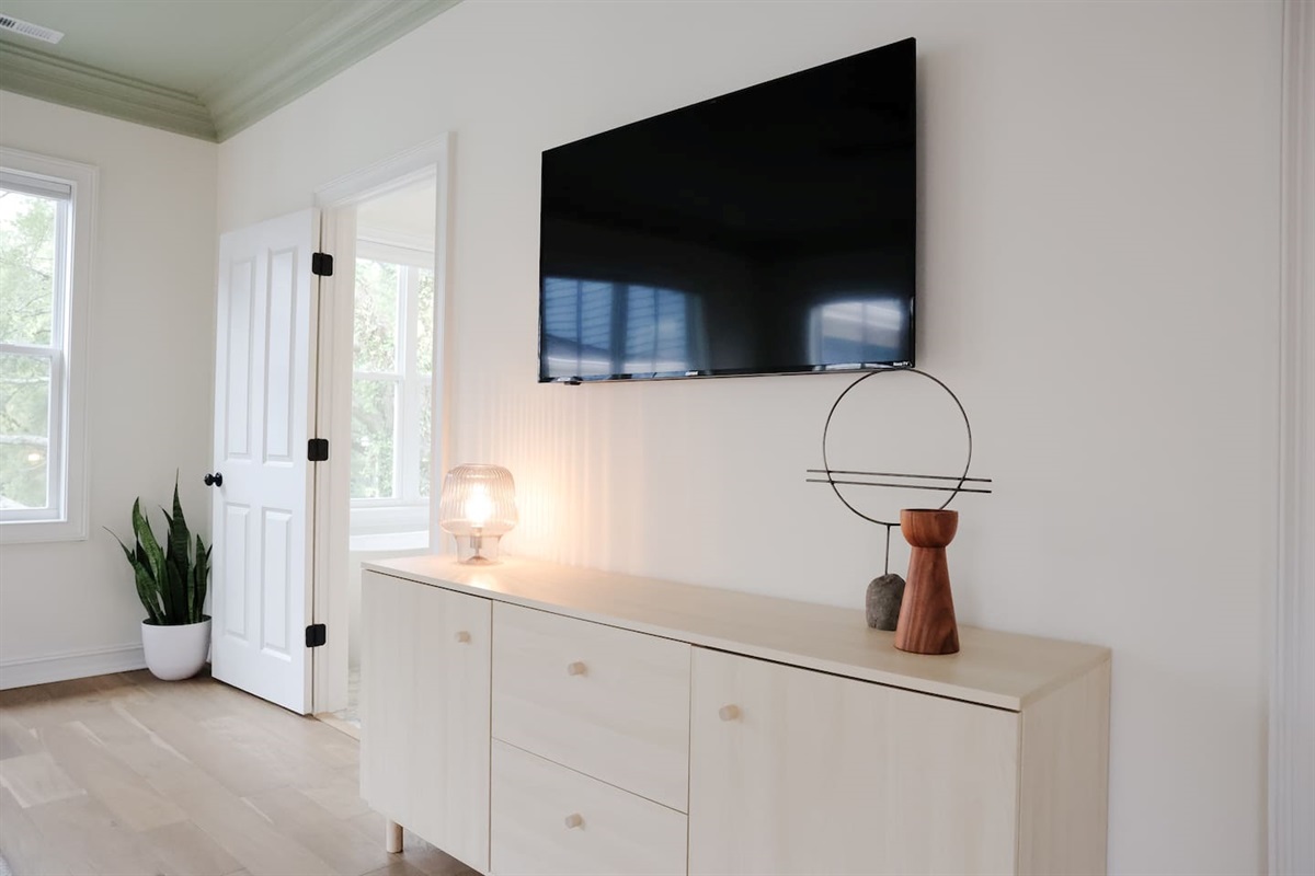 The spacious primary bedroom is a serene place to relax and recharge. The primary features a king sized bed, accents from CB2, walk-in closet, 50" Smart TV, and a full bath with a soaking tub and standup shower. 