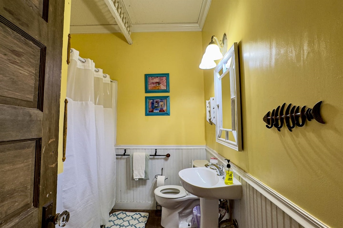 Well-equipped bathroom with a shower/tub, warm lighting, and thoughtful touches for comfort.