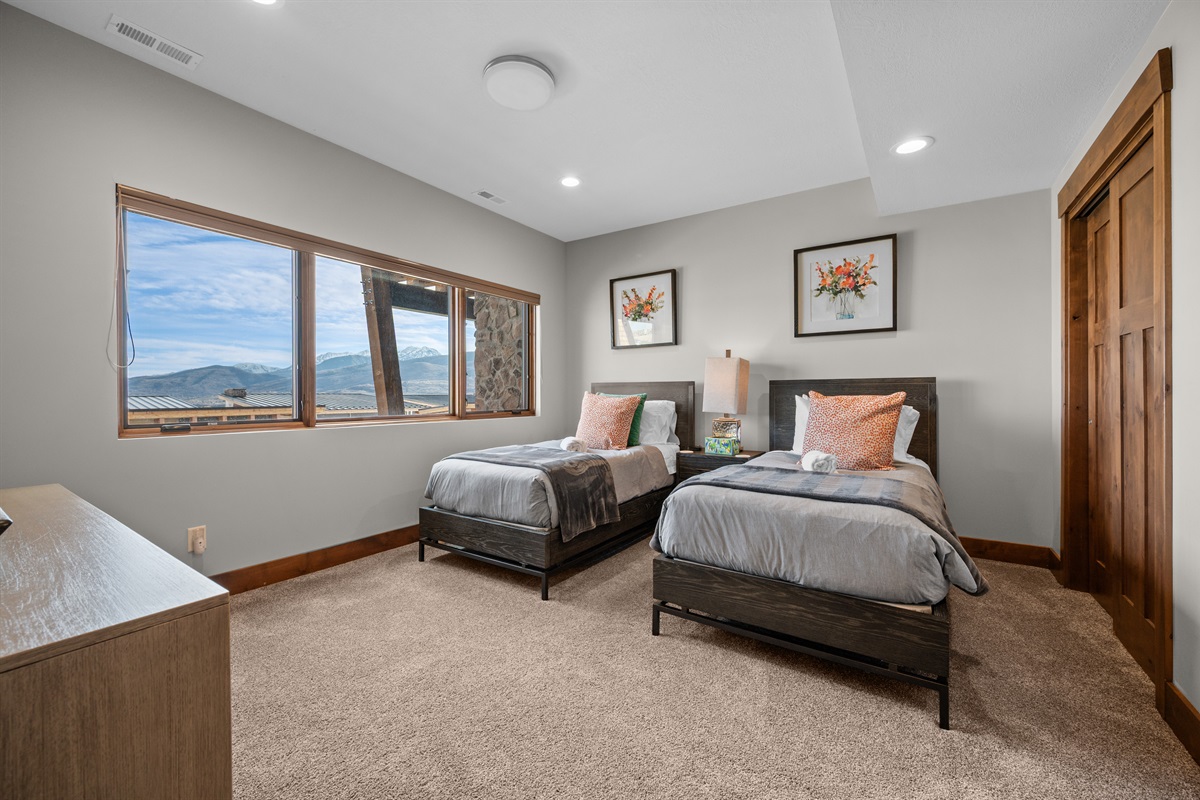 The third bedroom is outfitted with two twin beds, luxurious linens, and plush pillows. It has an ensuite bathroom and is located on the lower level.
