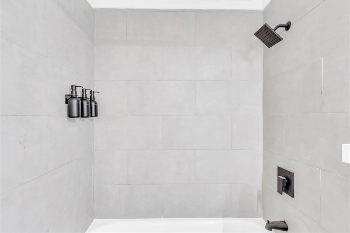 Bathroom with walk-in shower and sleek tile finish and luxe bath products.