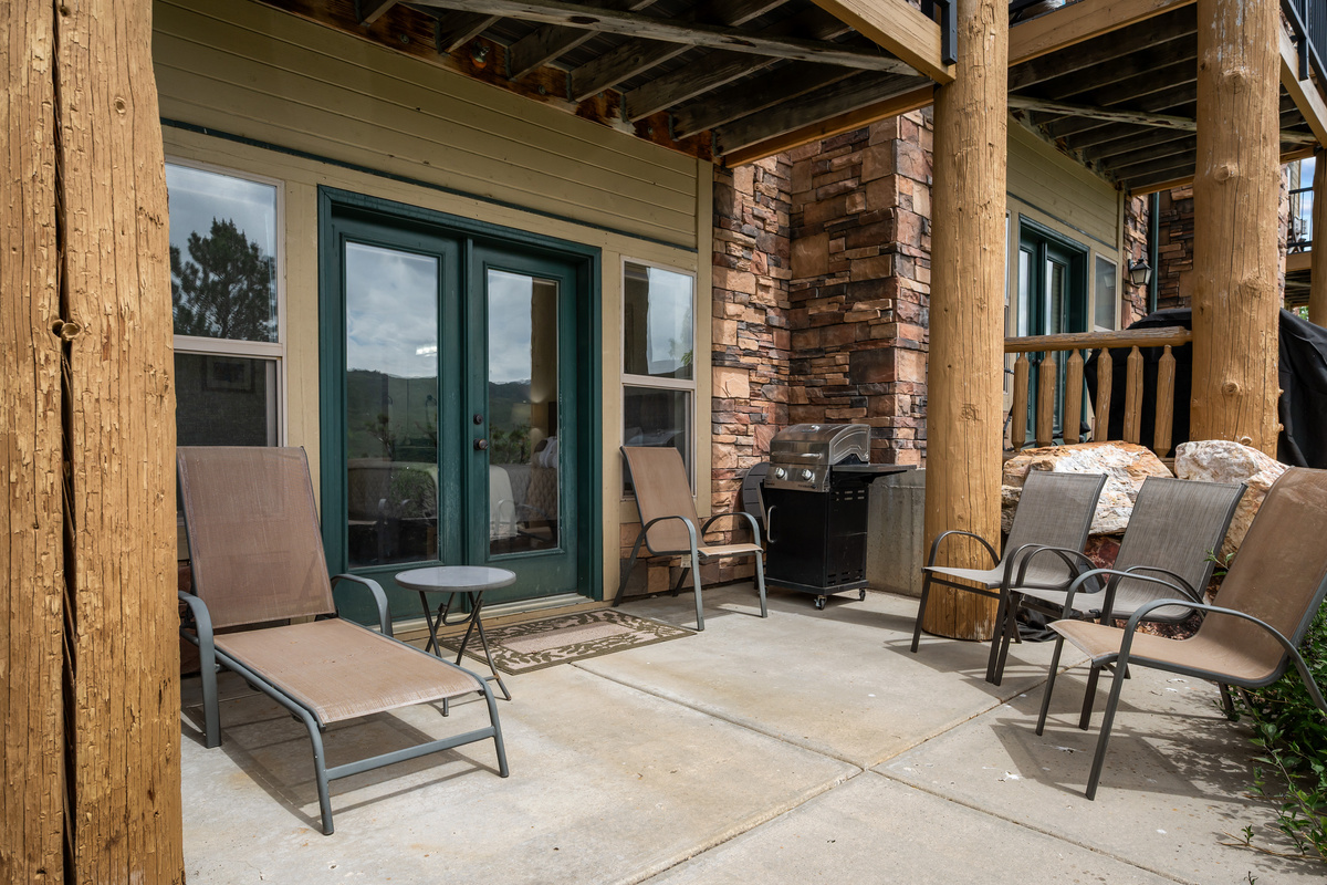 The covered patio offers comfortable outdoor seating, a BBQ grill, and the perfect place to unwind after a day of adventure.