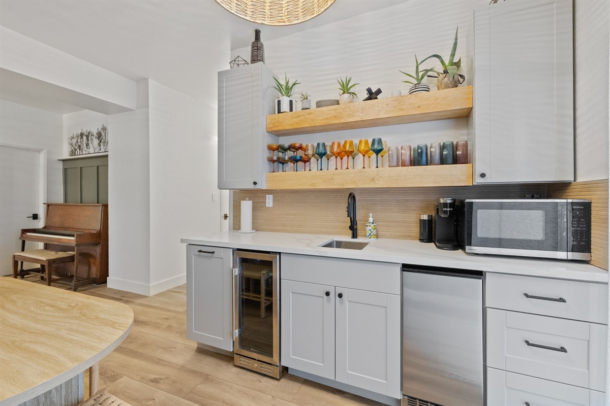 Downstairs kitchenette complete with sink, plastic drink-ware, microwave, mini fridge, ice maker and keurig. Also has a dining table that seats 6 and long bench seating with a plethora of games under it.