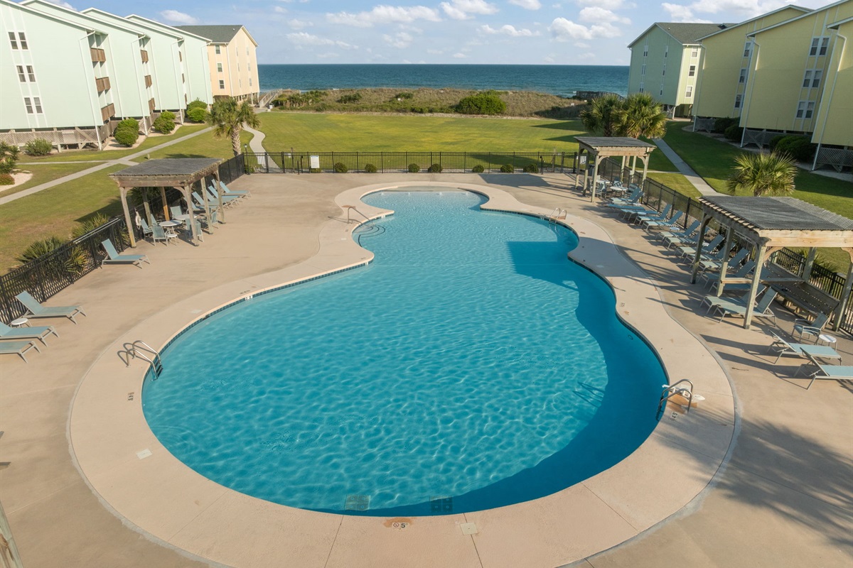 Cool off in the community pool just steps from the beach, with plenty of space to lounge and unwind
