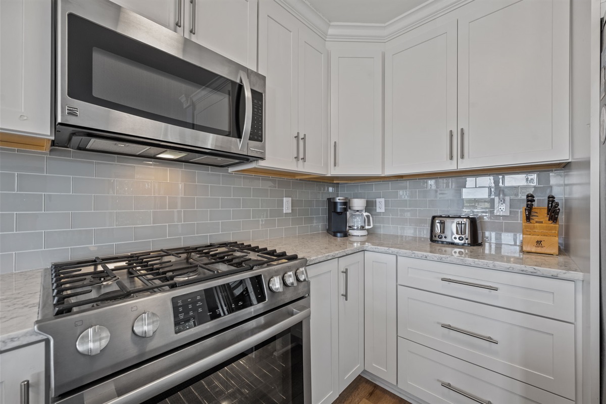 Sleek, updated appliances paired with white cabinets create a functional and stylish kitchen perfect for any meal.