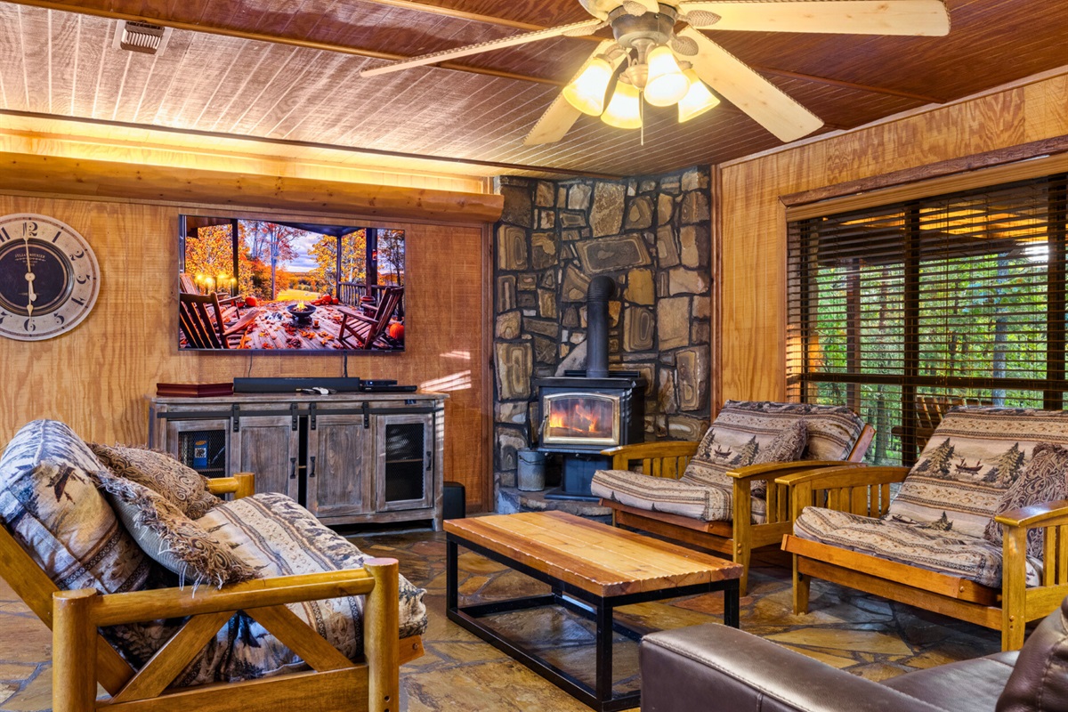 Cozy living room with woodsy décor and stone fireplace.
