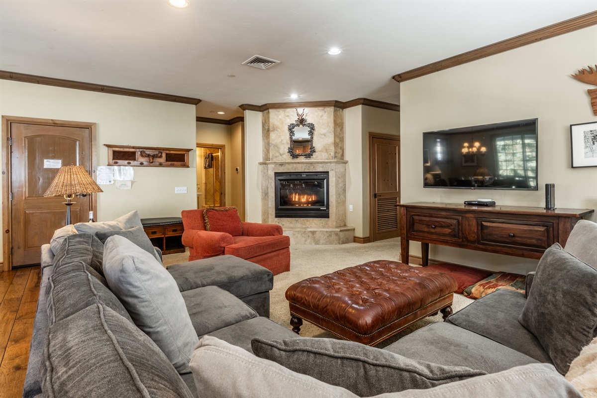 The Charming Chalet's comfortable living room with deep seating, warm fireplace, and a generous sectional—perfect after a day on the mountain.