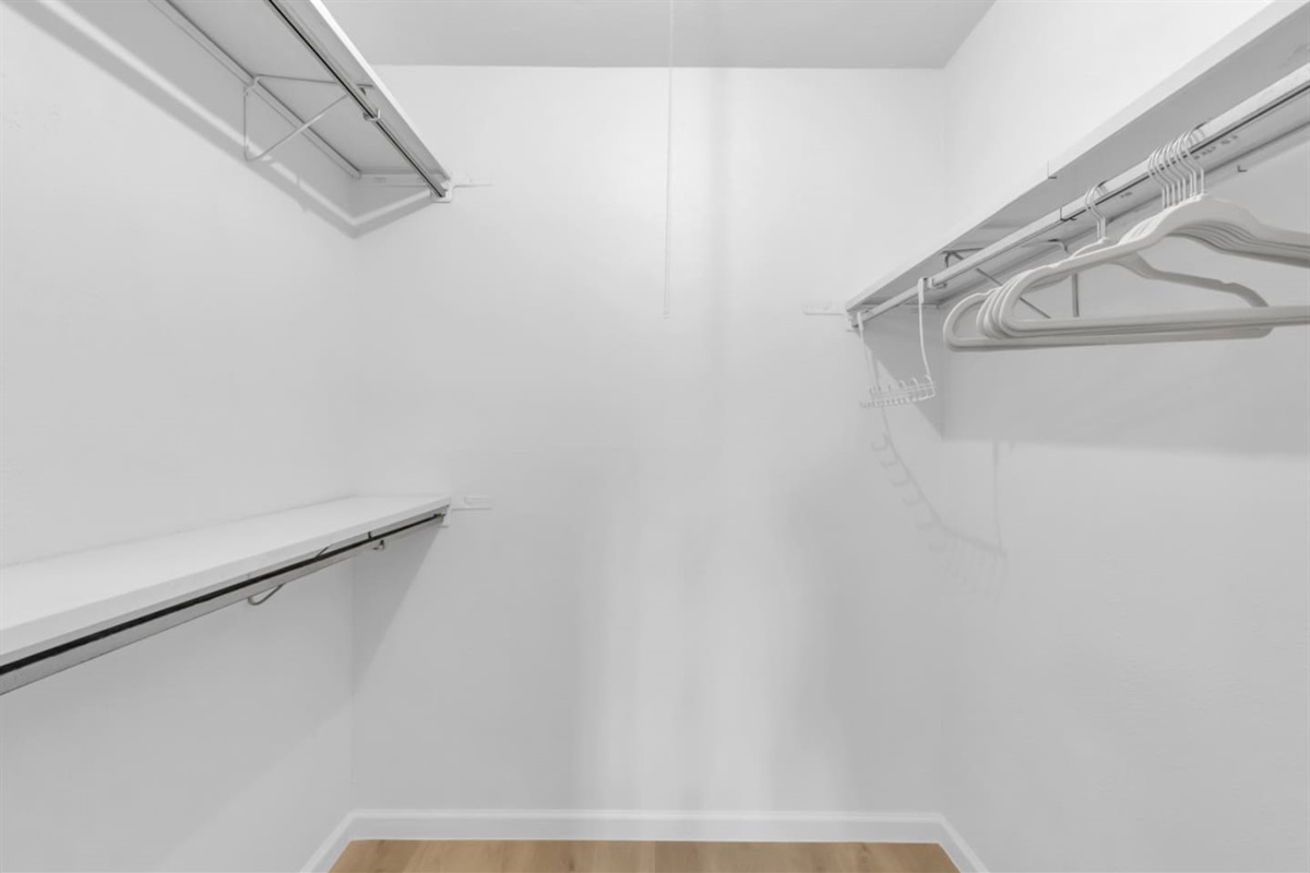 Expansive walk-in closet with abundant clothes storage, shelving, and hangers—perfect for extended stays or families needing extra space.