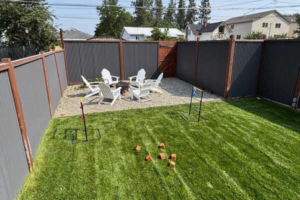 Game on! Ladder toss and giant yard dice on the lawn, with the fire pit circle just steps away — all inside the fully fenced backyard.