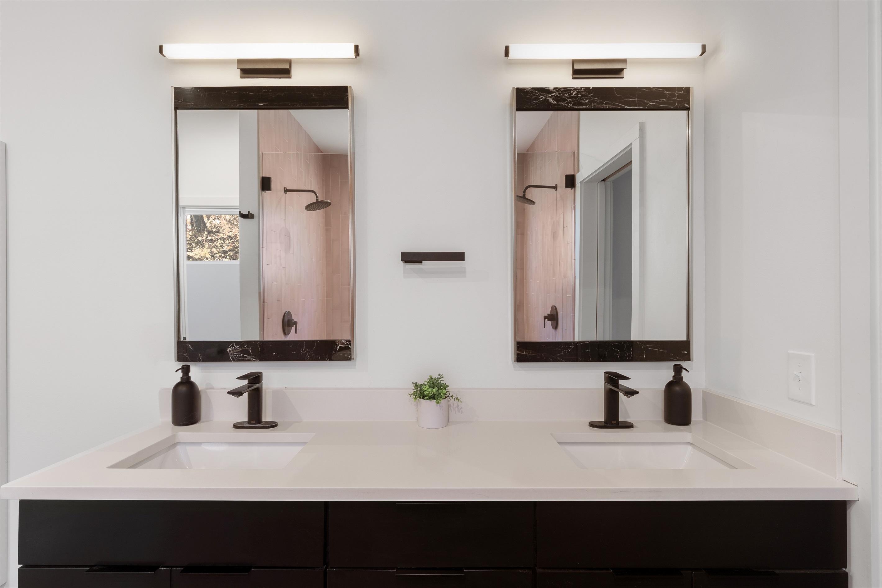 {Spa Bath - Glass House} Dual sinks with matte-black fixtures and warm lighting create a polished, spa-level experience