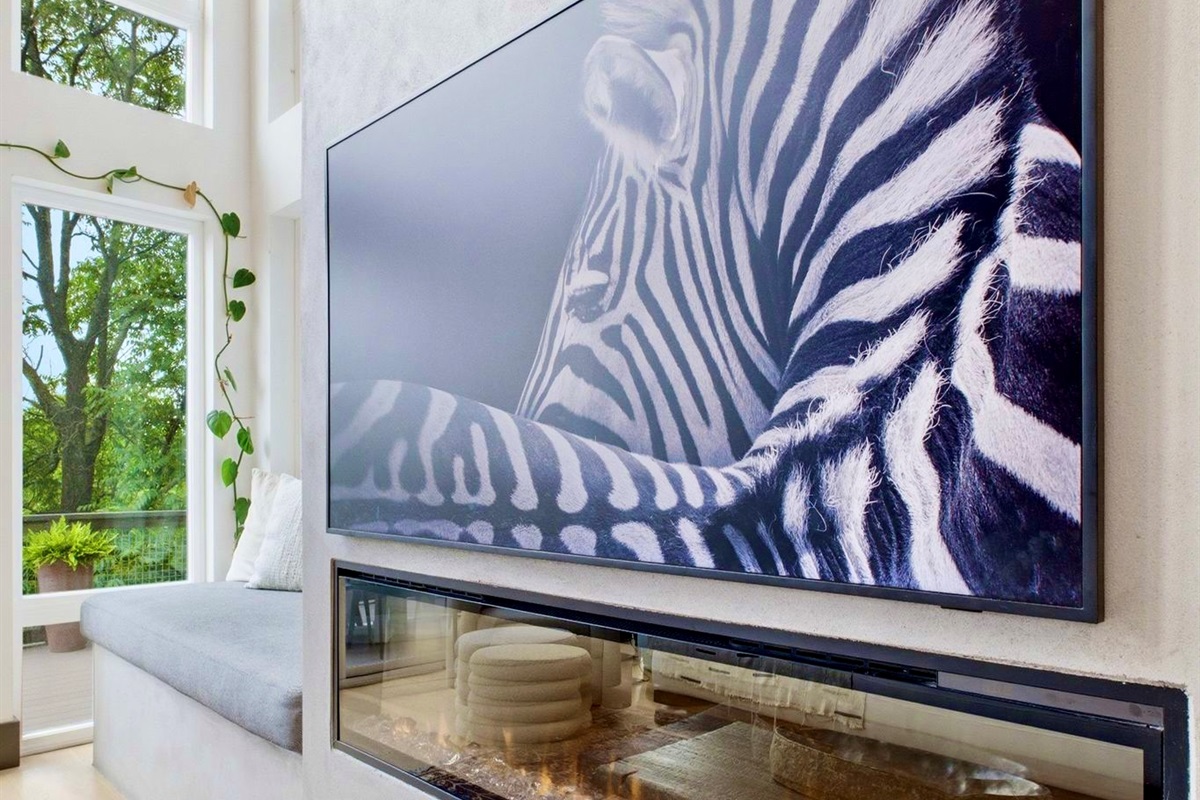 Bold zebra-print wall art anchors this eclectic lounge w/ a Union Jack throw & relaxed seating.

